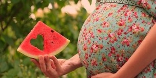 tranches de pastèque entre les mains de femmes enceintes